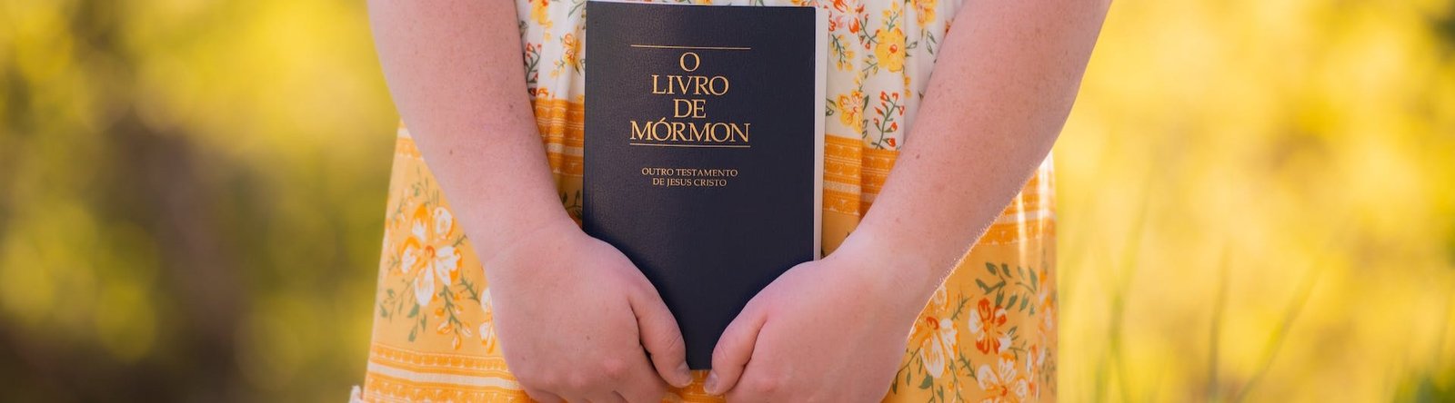 page hero, person holding a Book of Mormon