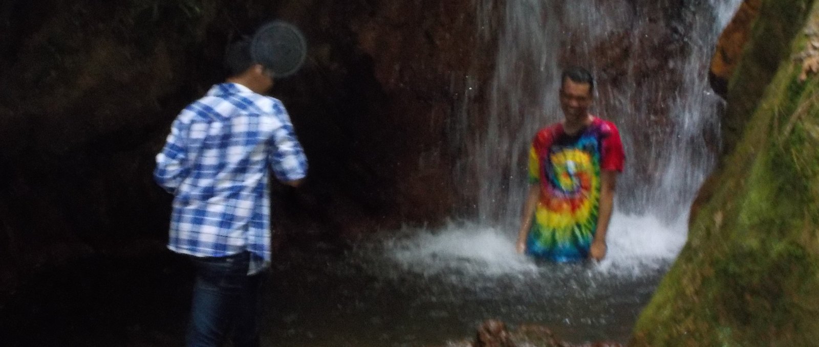 missionary and friend under a waterfall